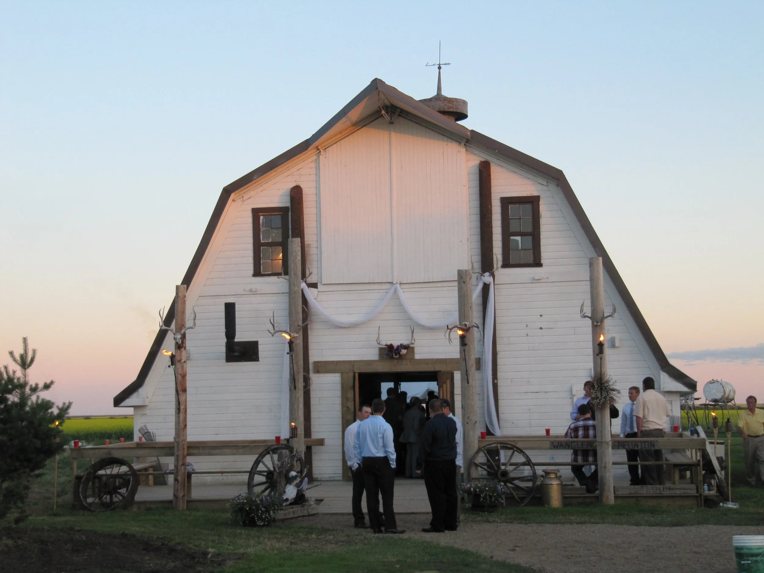 Front of the wedding barn with guests gathered near entrance.