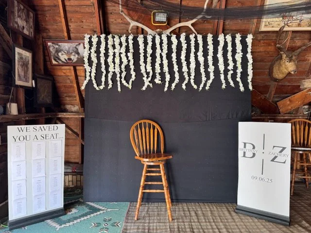 Wooden stool and rustic backdrop arranged for wedding photos.