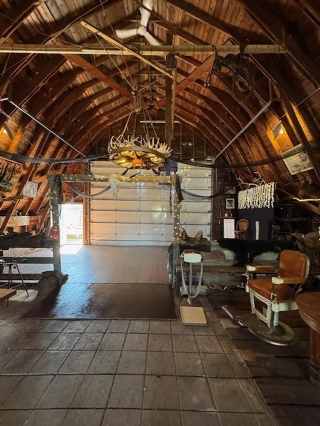 Spacious dance floor inside Top Gun Saloon with doors opening to the adjoining white event tent.