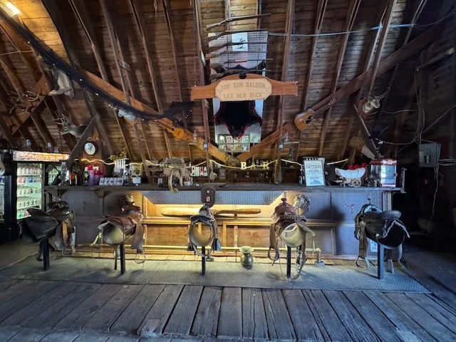 Licensed bar at Top Gun Saloon featuring handcrafted bar stools and wesern decor