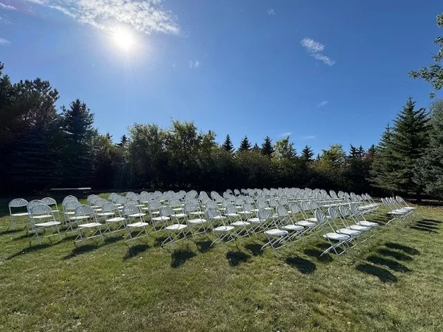 Outdoor event setup beneath sunny blue skies with seating for guests.