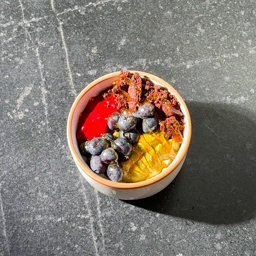 GREEK YOGURT BOWL WITH RASPBERRY PUREE, PISTACCHIO BUTTER, AND CHOCOLATE BISCUIT CRUMBLE