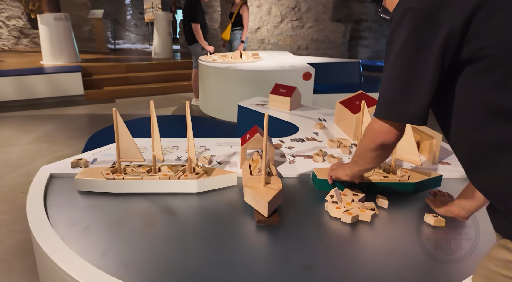 Visitors gathered around an interactive ship-building puzzle exhibit inside the Fat Margaret Maritime Museum in Tallinn, Estonia.