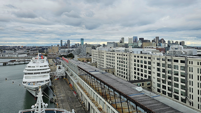 Cruise ship docked at Flynn Cruiseport Boston in the South Boston Seaport District, with the Boston skyline in the background