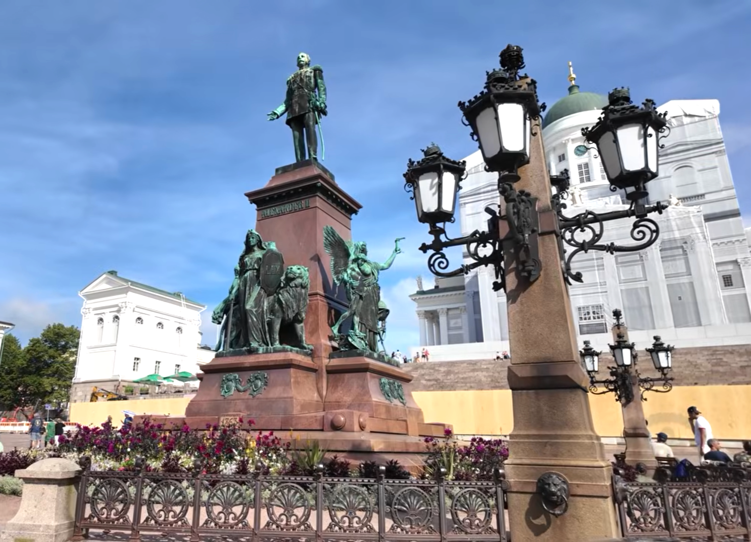 Statue of Alexander II in Senate Square with Helsinki Cathedral visible in the background under a blue sky.