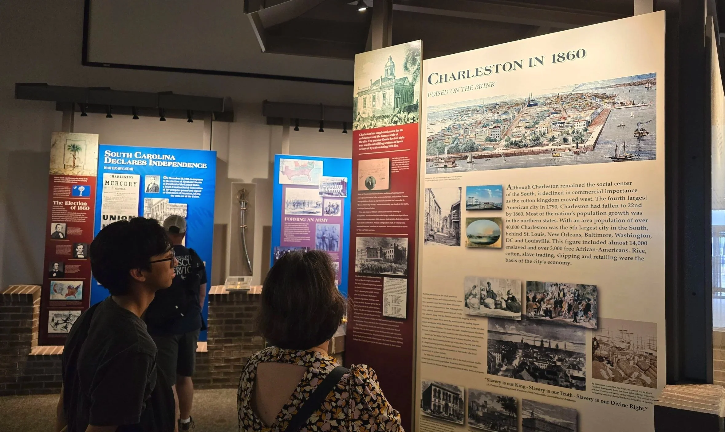 Visitors viewing a Charleston history exhibit about the city in 1860 at a museum near the Charleston cruise port