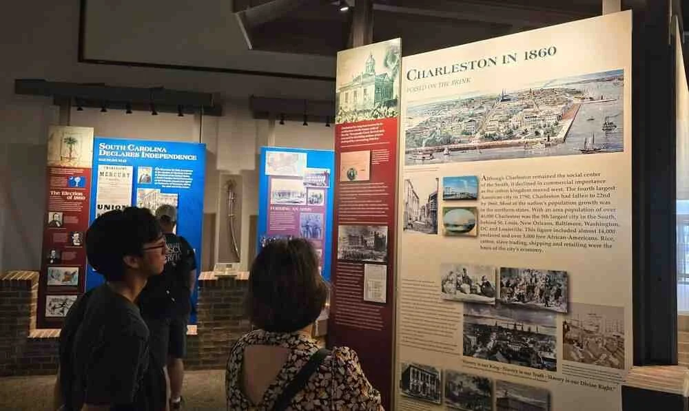 Visitors viewing a Charleston history exhibit about the city in 1860 at a museum near the Charleston cruise port