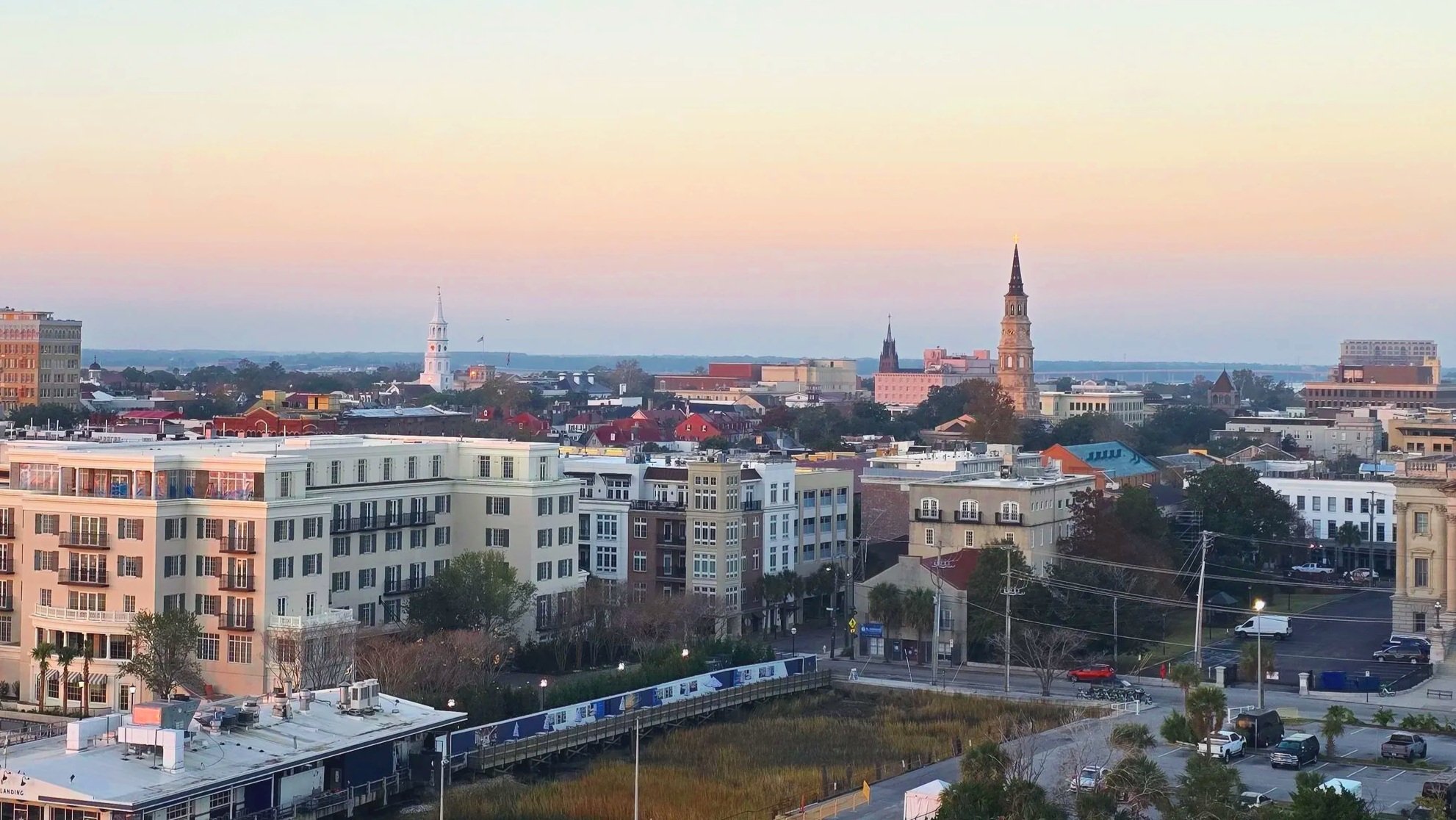 Historic downtown Charleston, South Carolina skyline viewed from the cruise port, with church steeples, waterfront buildings, and sunset views