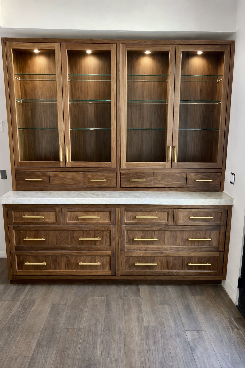 Walnut Built-in with brass handles and glass doors and glass shelves