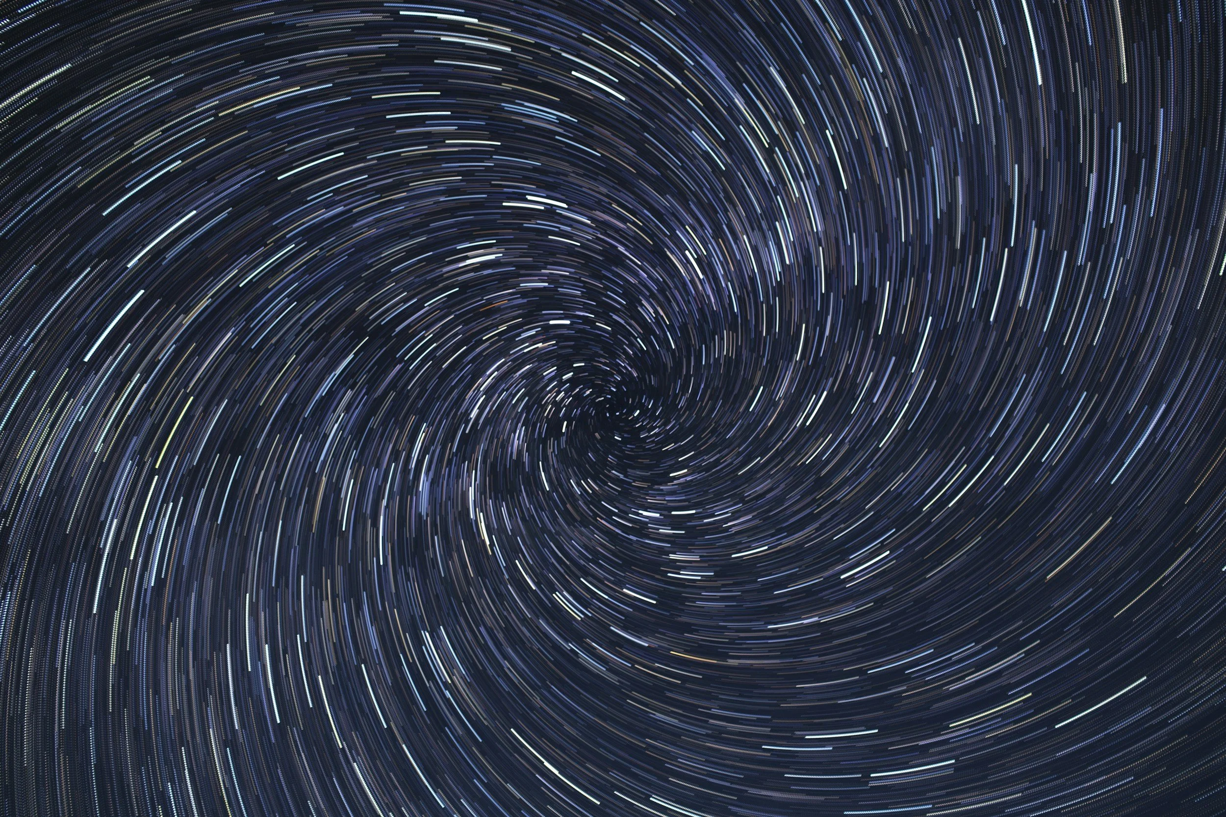 Long exposure photograph of star trails in the night sky, creating circular streaks of light.