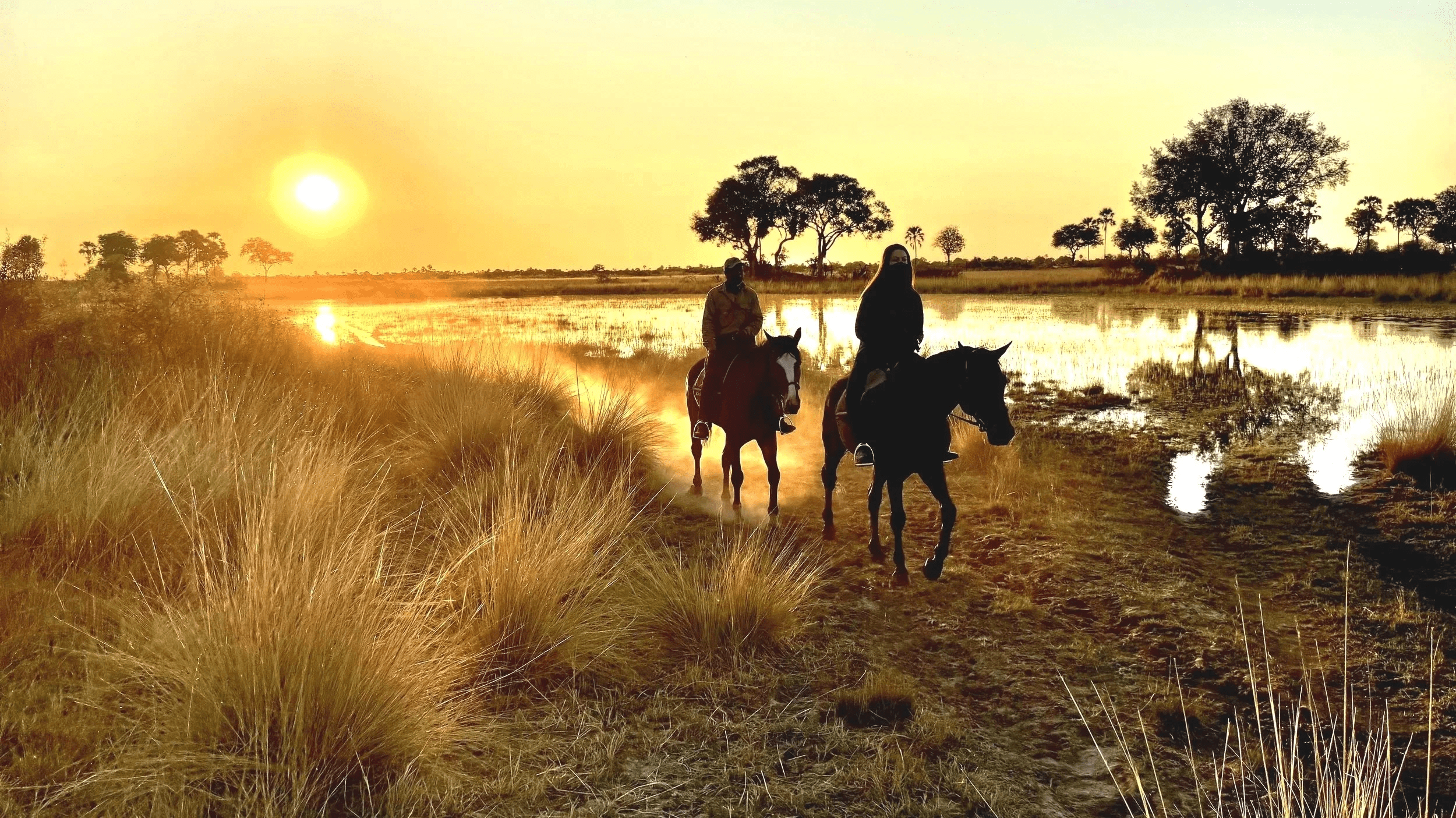 Two riders on a Uganda Nile horseback safari at sunset