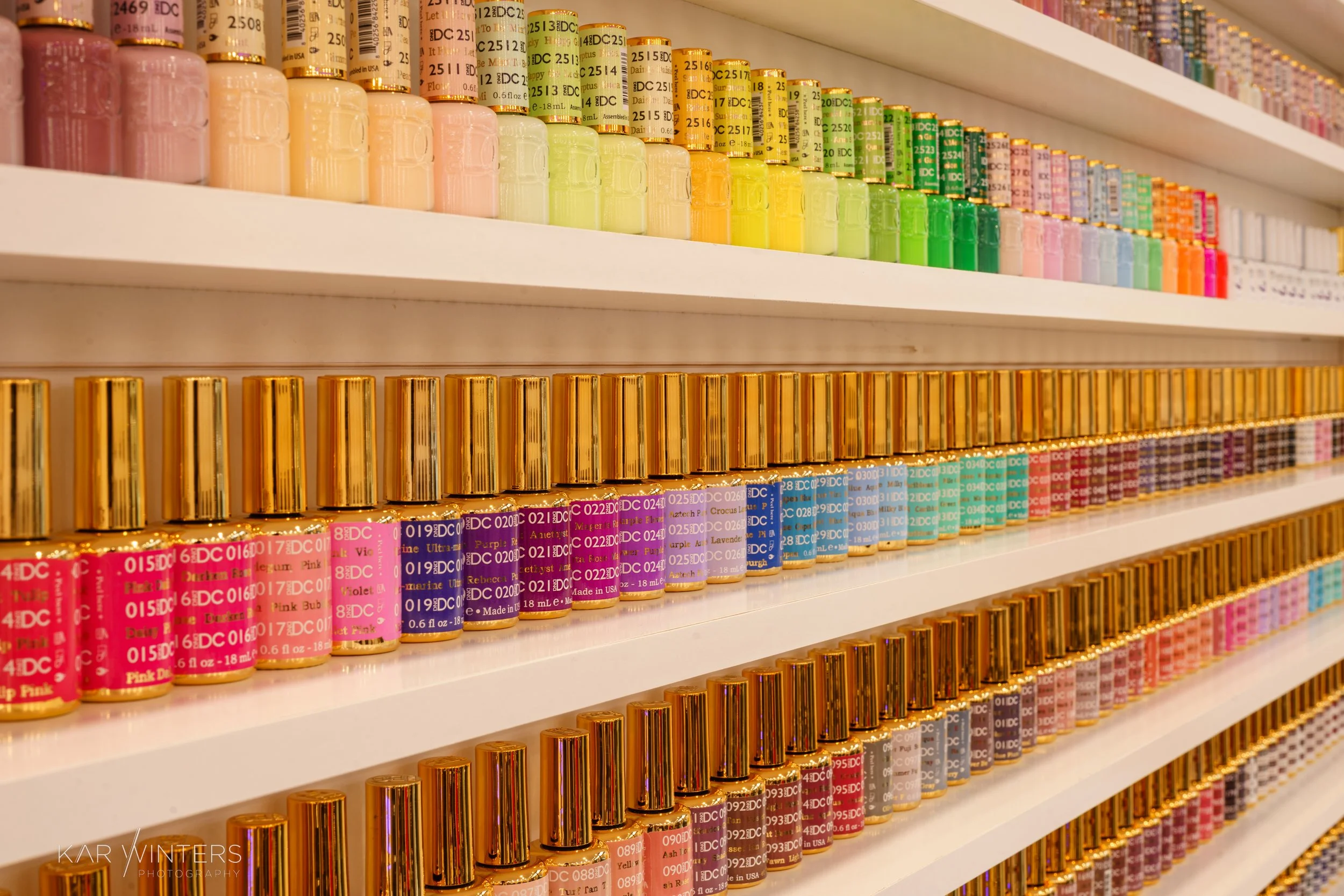 Shelves stocked with colorful bottles of nail polish in a store.