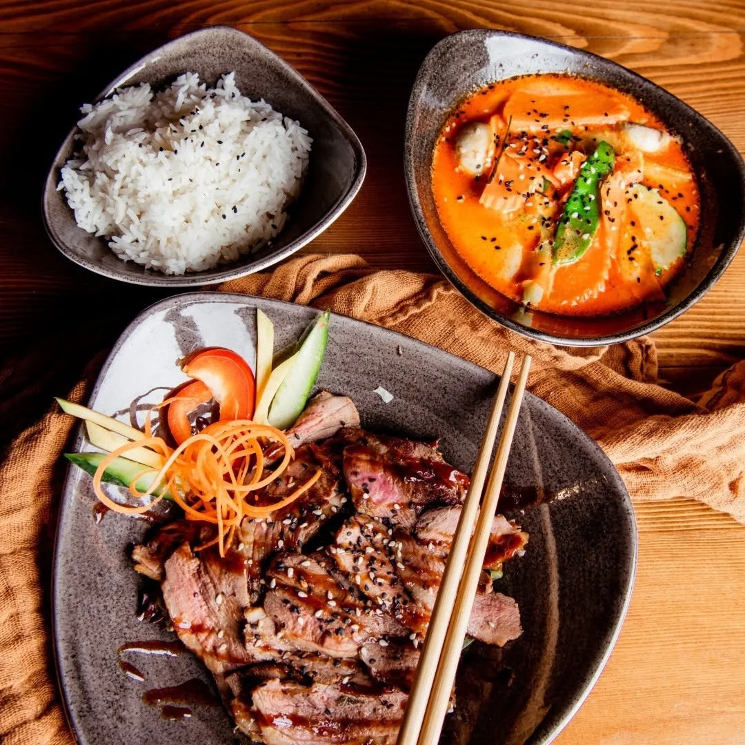 Asiatisches Gericht mit Reis, Tom Yam Suppe und gegrilltem Fleisch mit Gemüse
