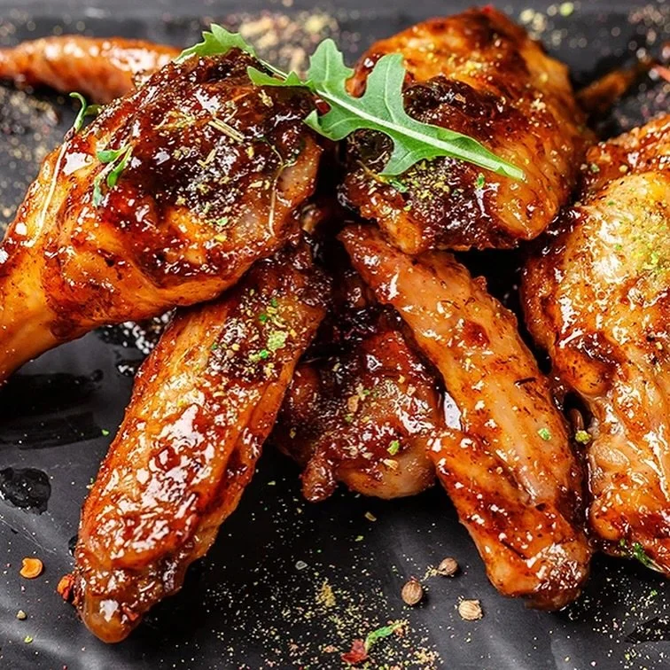 gebratene Spareribs mit Gewürzen und Garnitur auf einem schwarzen Teller