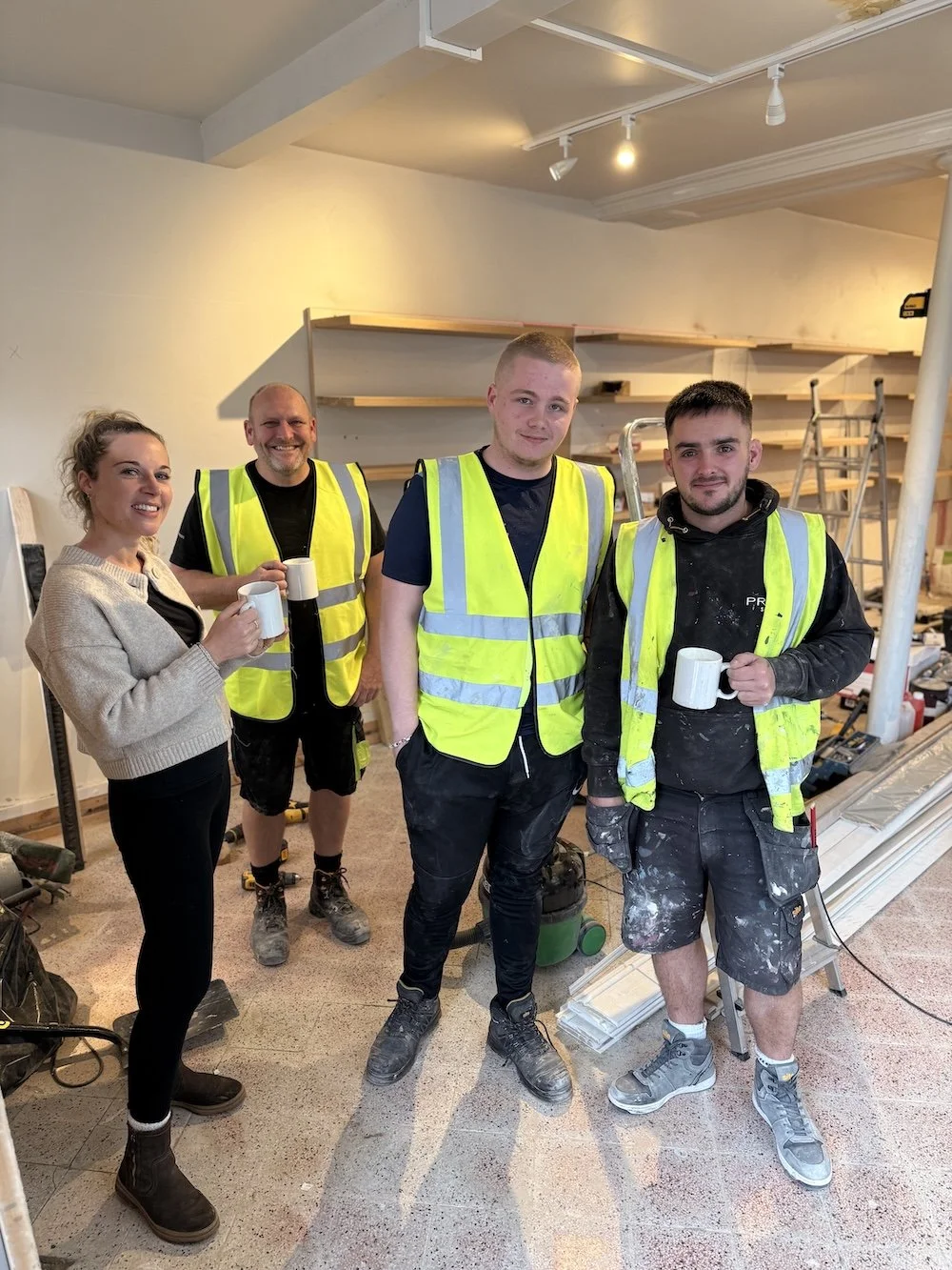builders with a cup of tea and a woman holding a cup of tea