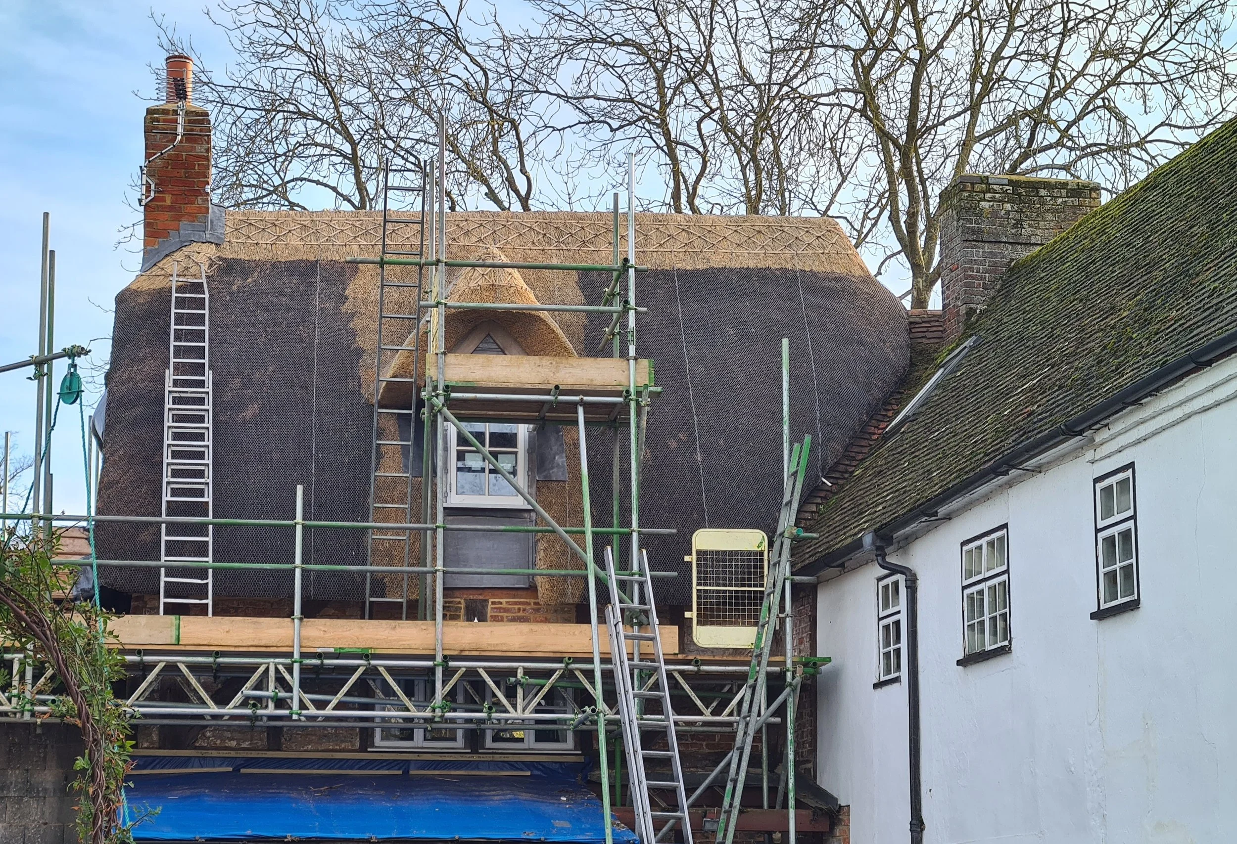 House with thatch repair and new gable dormer window