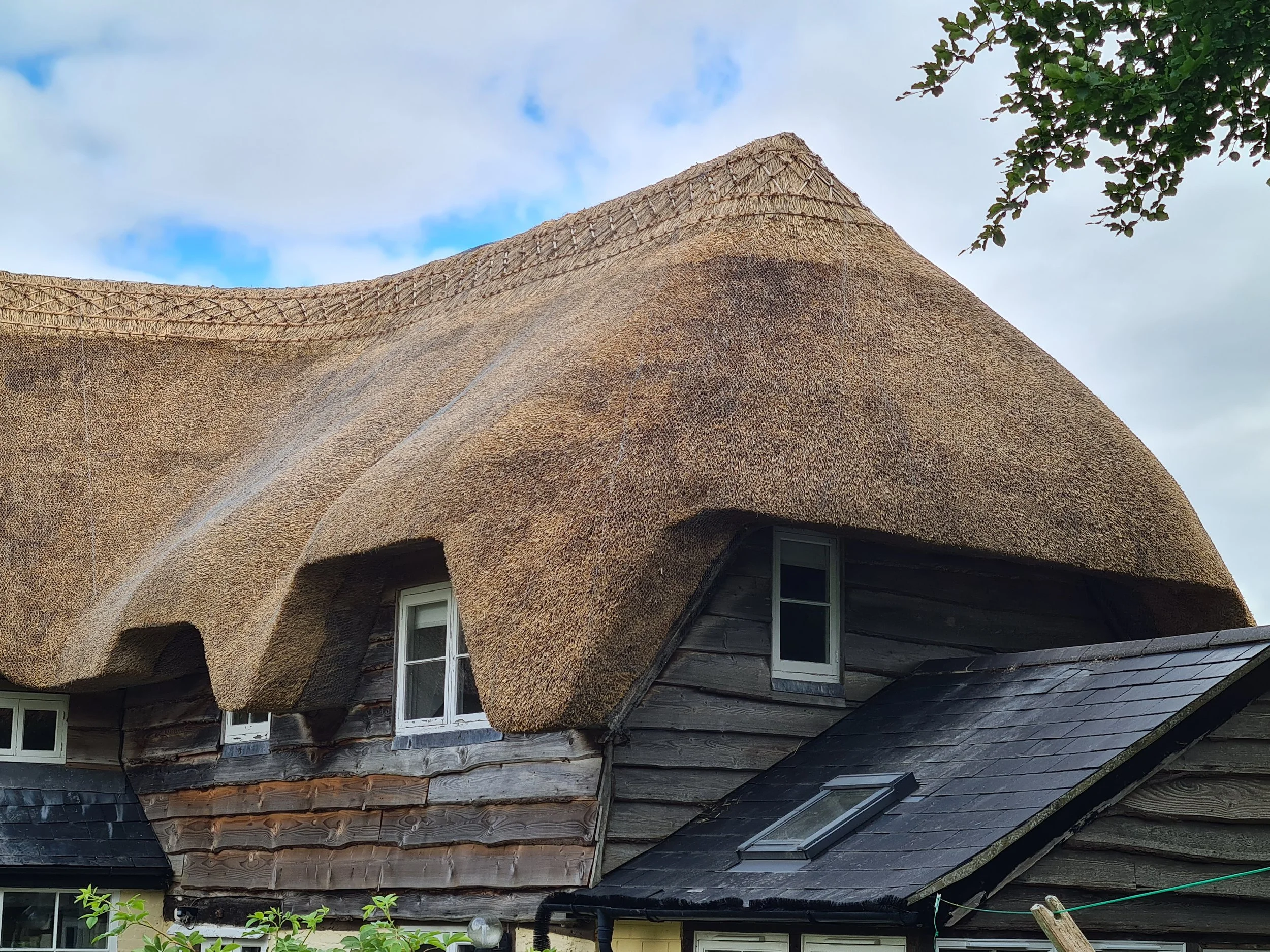 A house with a thatched roof and flush ridge