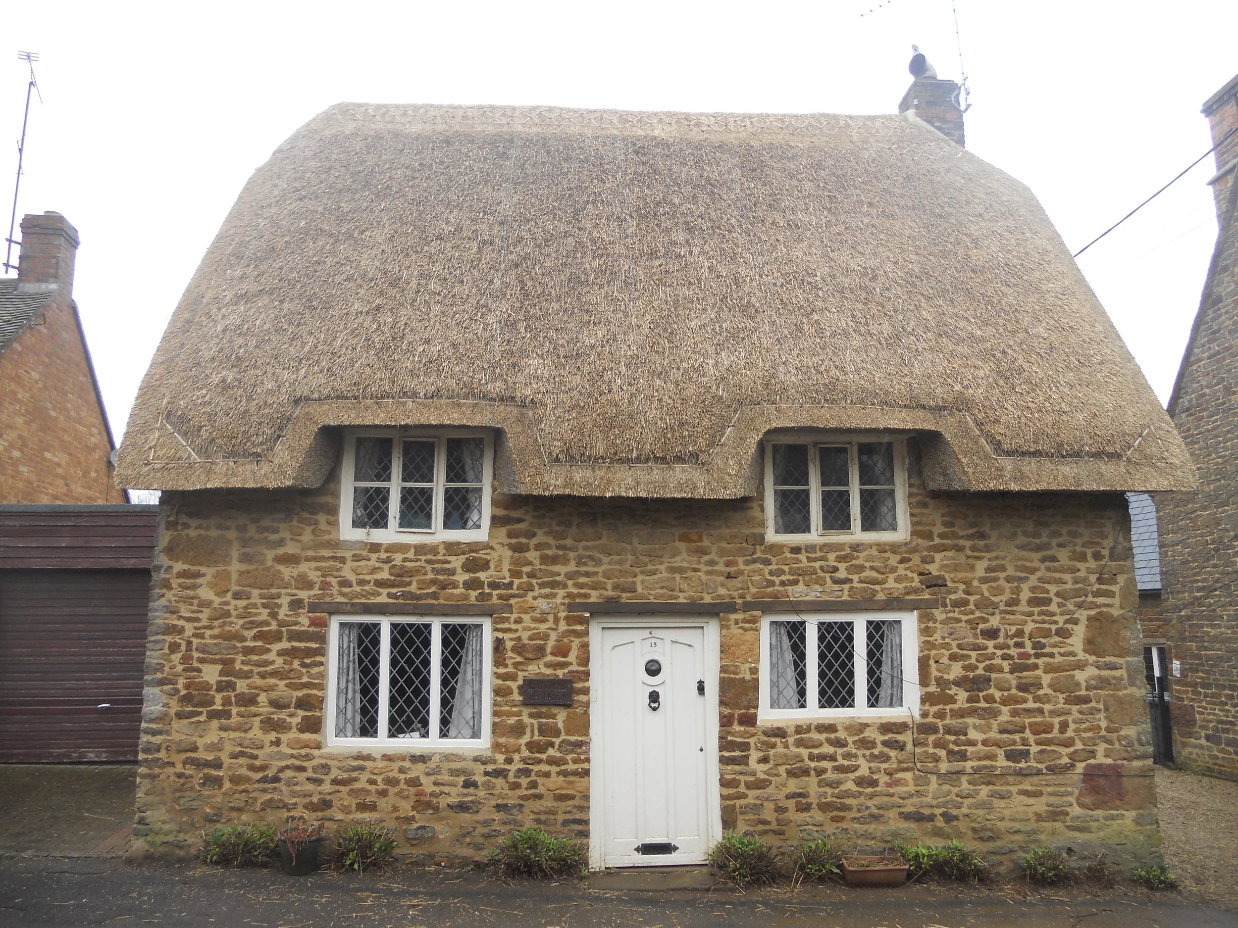 Stone cottage with thatched roof and flush ridge