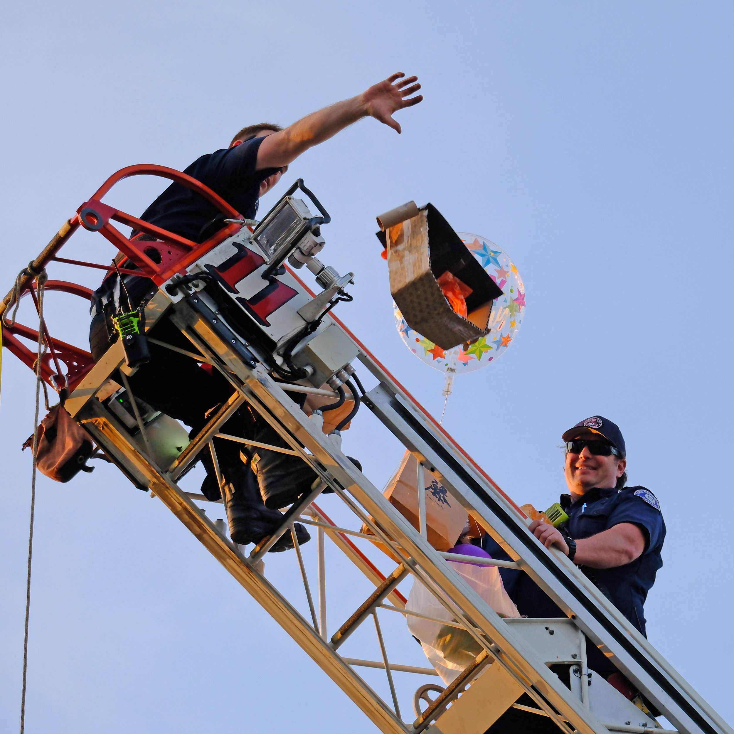 Two Firefighters at the top of ladder dropping egg drop vehicle.jpg