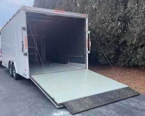 A white enclosed trailer with its rear ramp door open