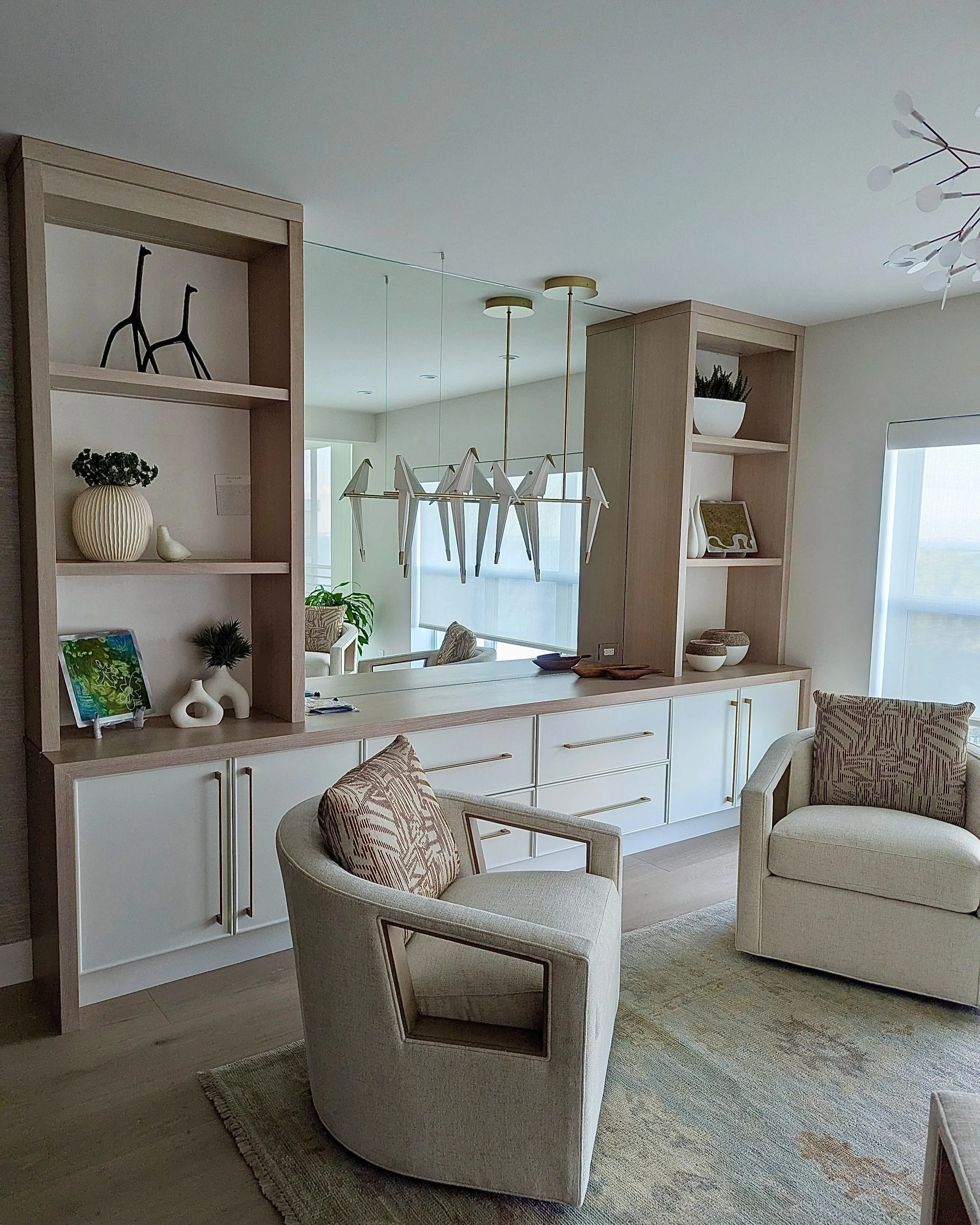 Living room with built-in wooden shelving, and custom fit mirror inset.