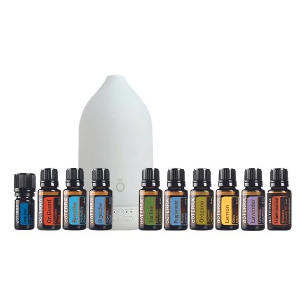 Essential oil diffuser surrounded by ten small bottles of doTERRA essential oils with labels for various scents.
