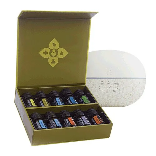 A box of essential oils with ten bottles arranged inside and a white essential oil diffuser beside it.