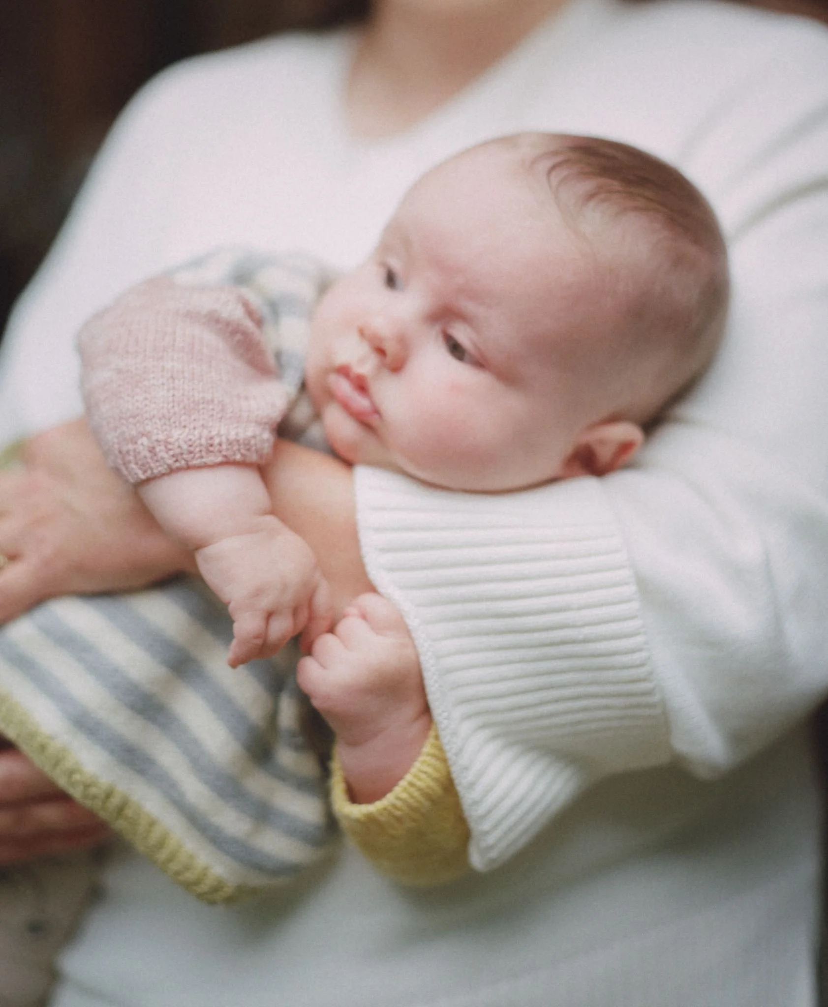 A baby cradled in their mothers arm photographed on medium format film in the Macedon Ranges