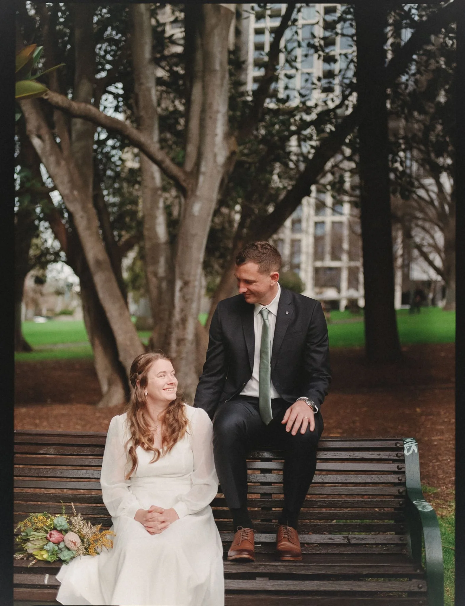 Nell and Alexander photographed on film in Treasury Gardens after their intimate Melbourne Registry Office elopement