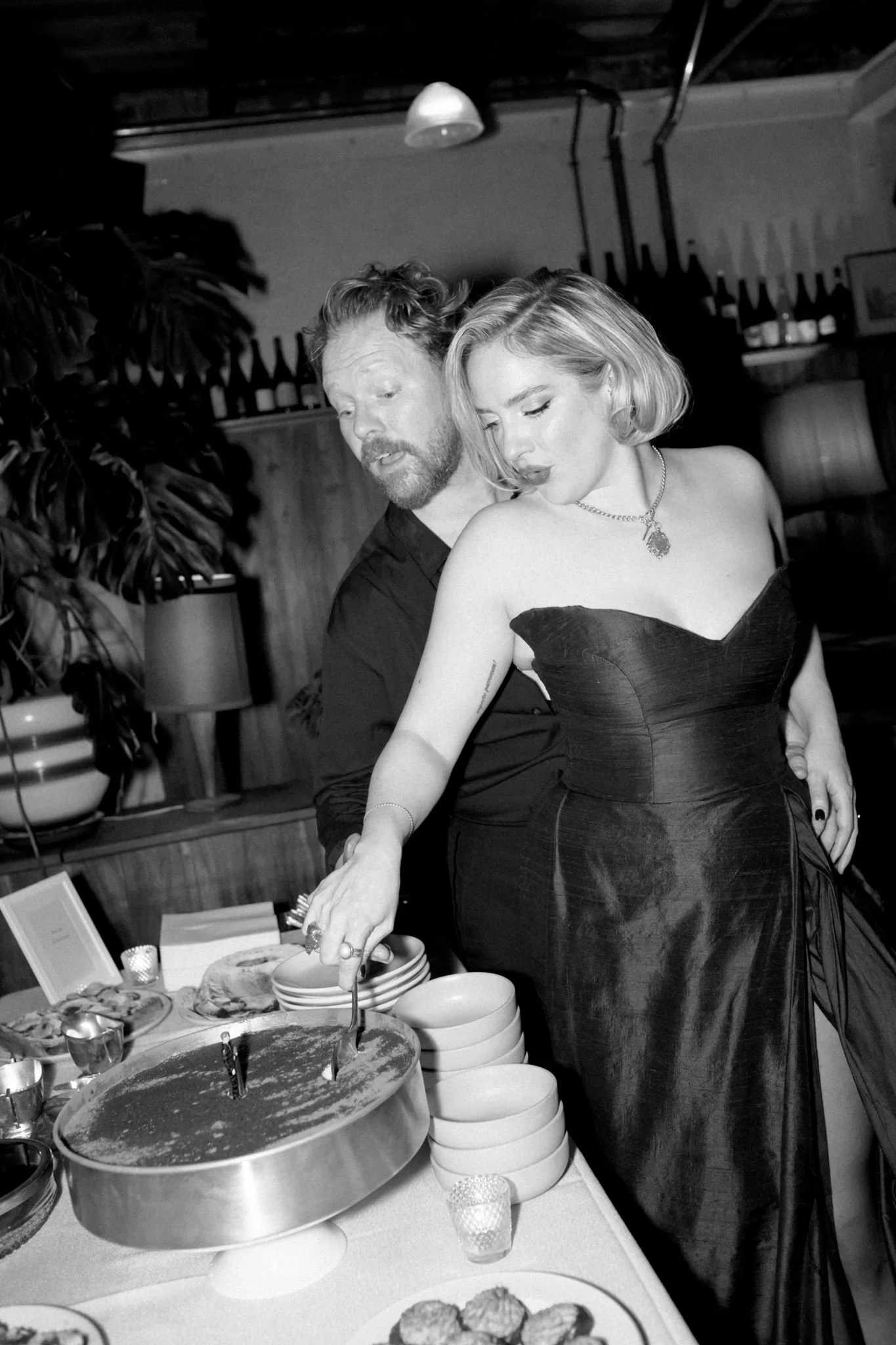 Black-and-white film photograph of Annabelle and Dom serving tiramisu at their intimate restaurant wedding at Old Palm Liquor in Melbourne.