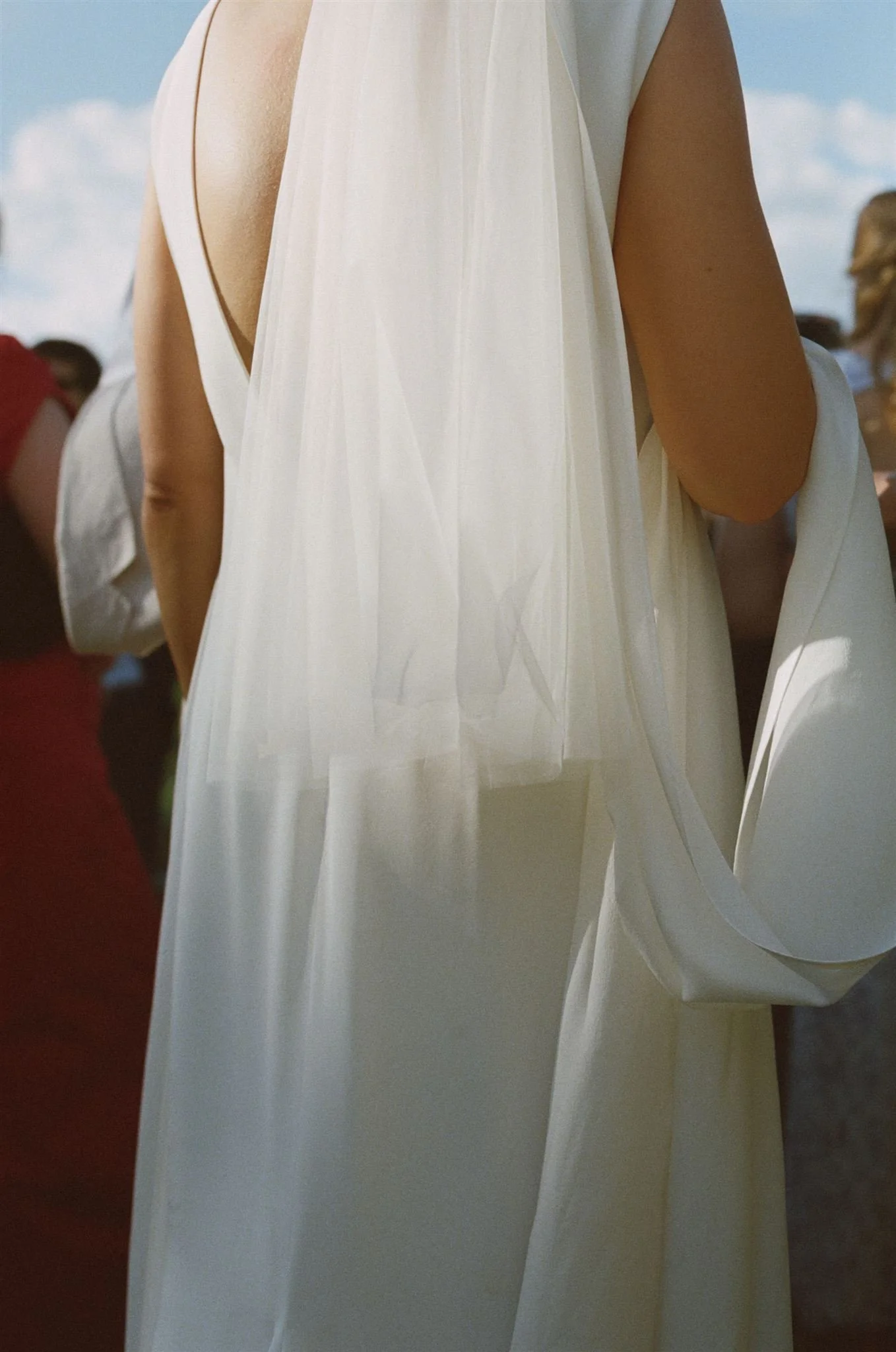 The back of a brides dress, showing off her veil, the photo is taken on 35mm film. 