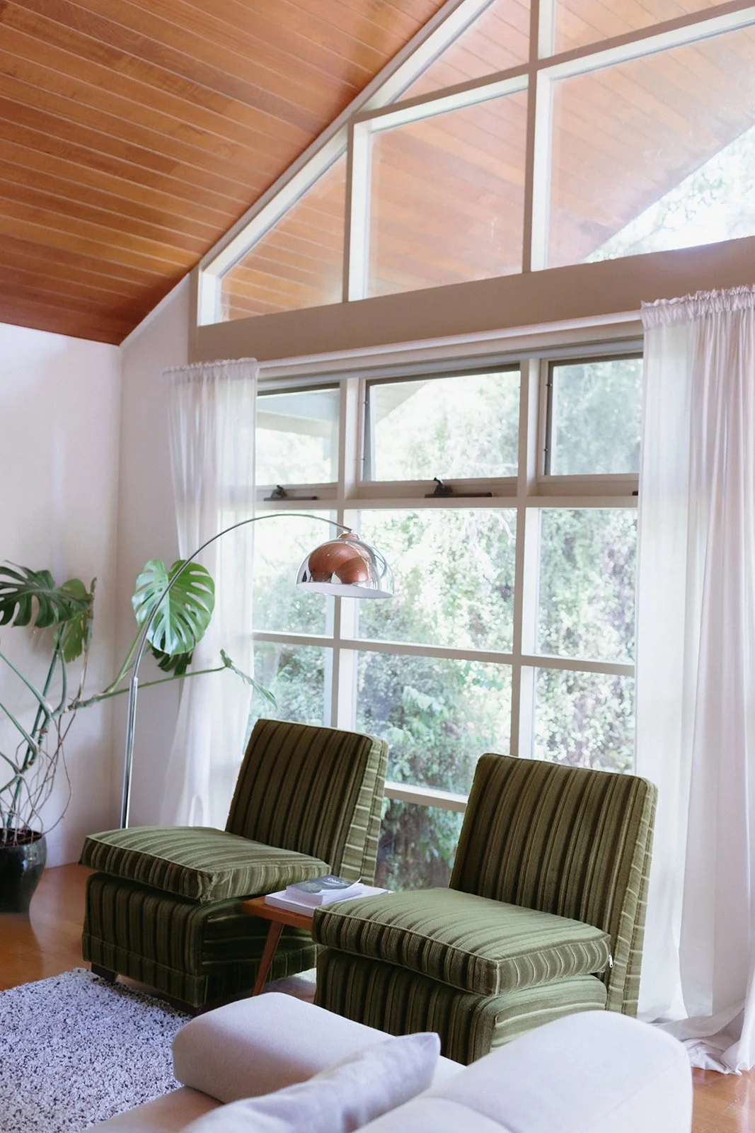 Light and bright accommodation in Daylesford, two vintage velvet chairs in front of big windows.