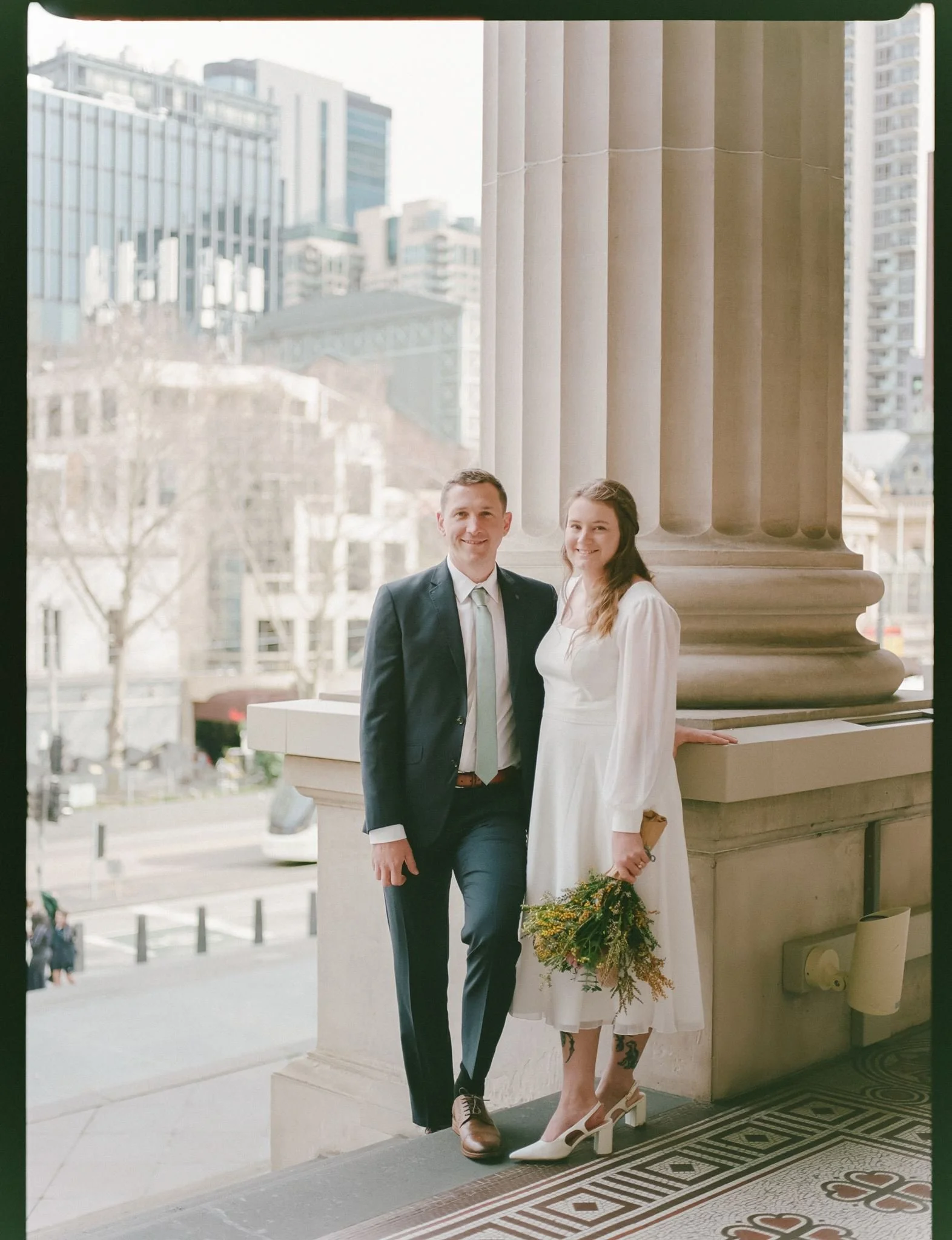 Newlyweds Nell and Alexander outside the Old Treasury Building after their Melbourne Registry wedding, photographed on analogue film
