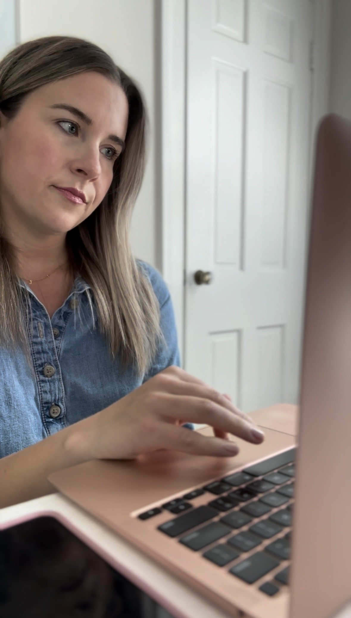 Kelly sits at her computer, visibly annoyed.