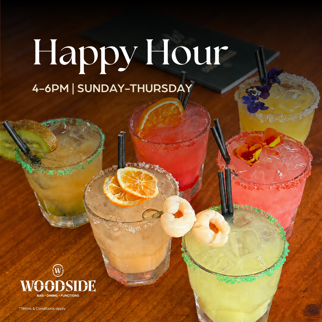 Assorted cocktails and beverages on a wooden table with various garnishes such as mint, lemon, and cucumber. Text overlay announces 'Happy Hour, $2 off all drinks! 4PM - 6PM.'