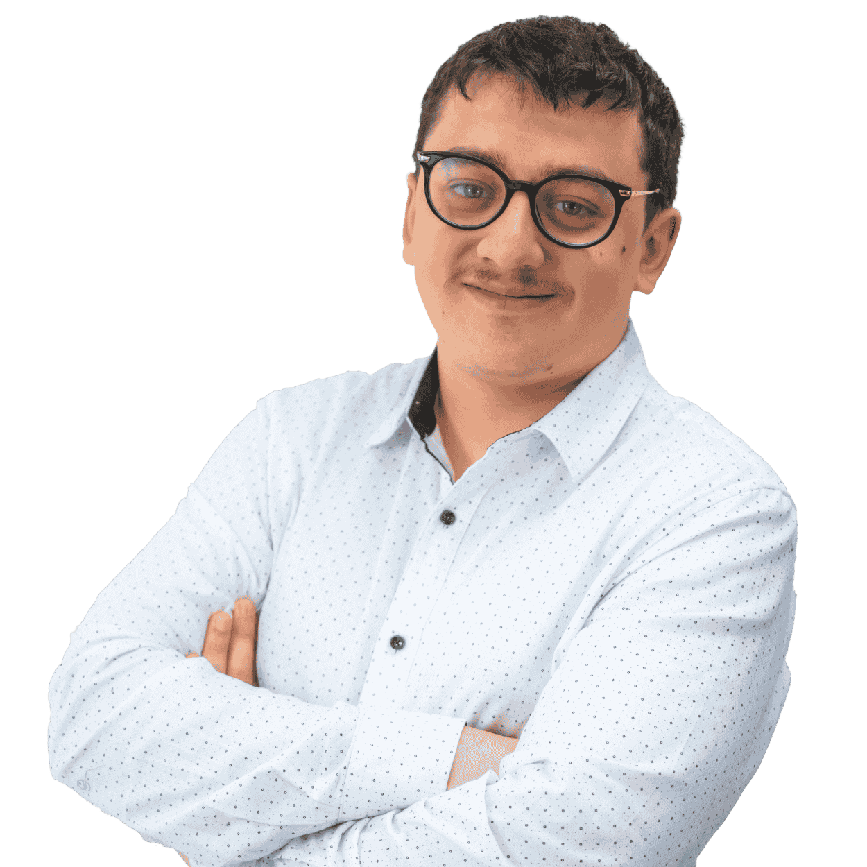 A young man with glasses, wearing a white, dotted button-up shirt, with arms crossed, smiling, against a black background.