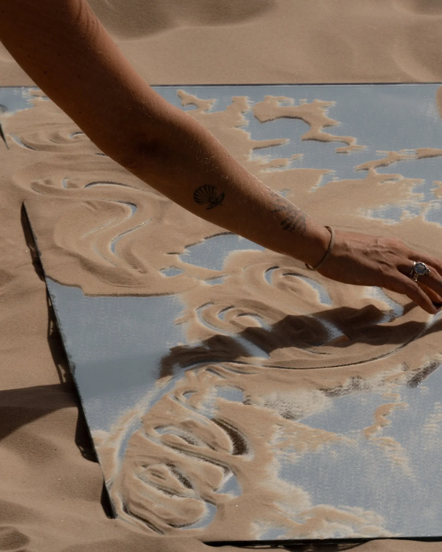 𝐀𝐥𝐦𝐨𝐬𝐭 𝐄𝐥𝐬𝐞𝐰𝐡𝐞𝐫𝐞 | 𝐒𝐭𝐨𝐫𝐲 𝐕

Mirrors in the dunes.

A simple object, yet suddenly the landscape doubles, shifts, fragments. Reflections catch the curves of sand, the light, the movement of the girls.
Some mirrors hold the body. So