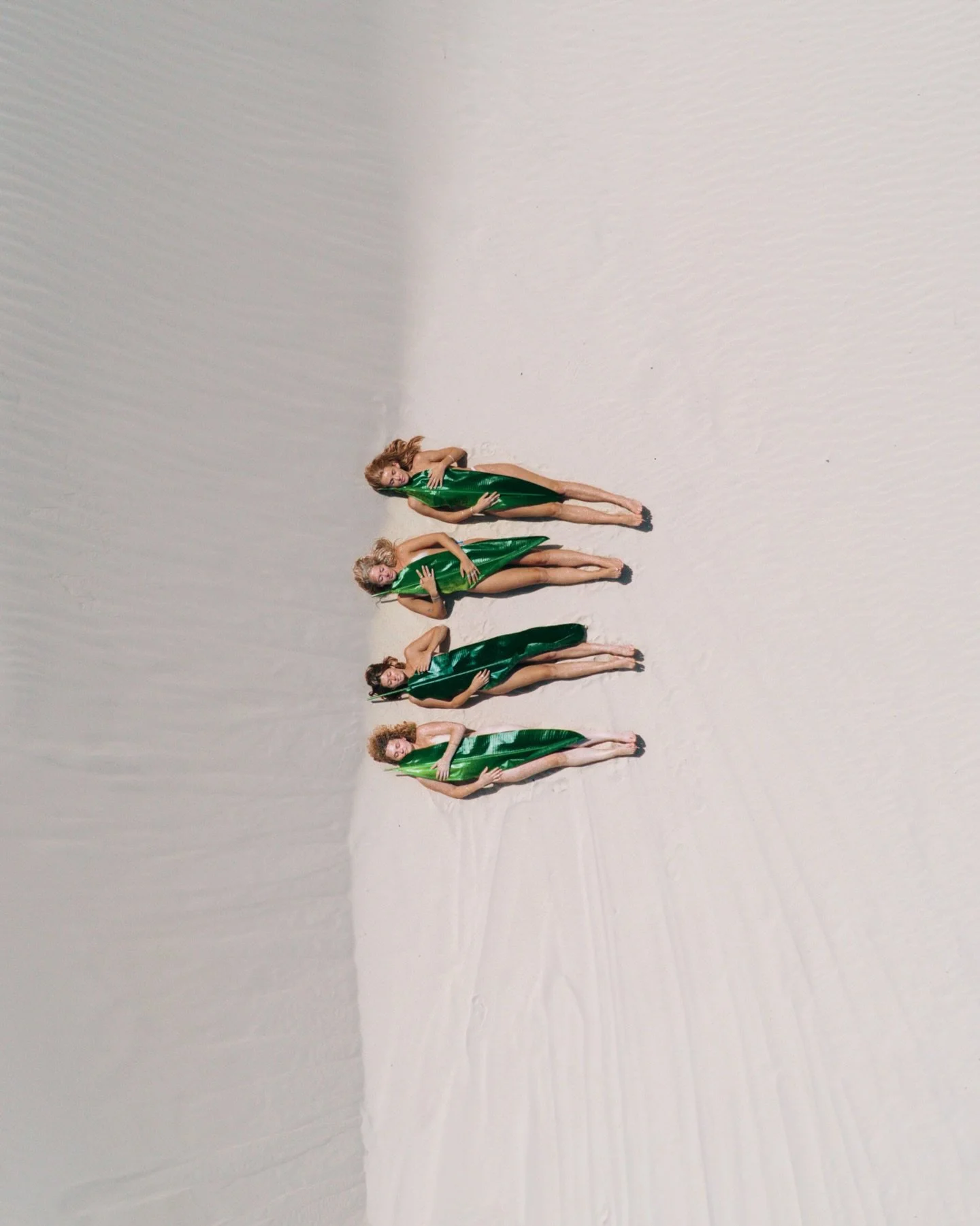 𝐀𝐥𝐦𝐨𝐬𝐭 𝐄𝐥𝐬𝐞𝐰𝐡𝐞𝐫𝐞 | 𝐒𝐭𝐨𝐫𝐲 𝐕𝐈

Bodies draped in leaves.

Banana leaves become clothing, sculpture and camouflage all at once. They move with the wind, echo the curves of the dunes and merge the human form with the landscape.

Some