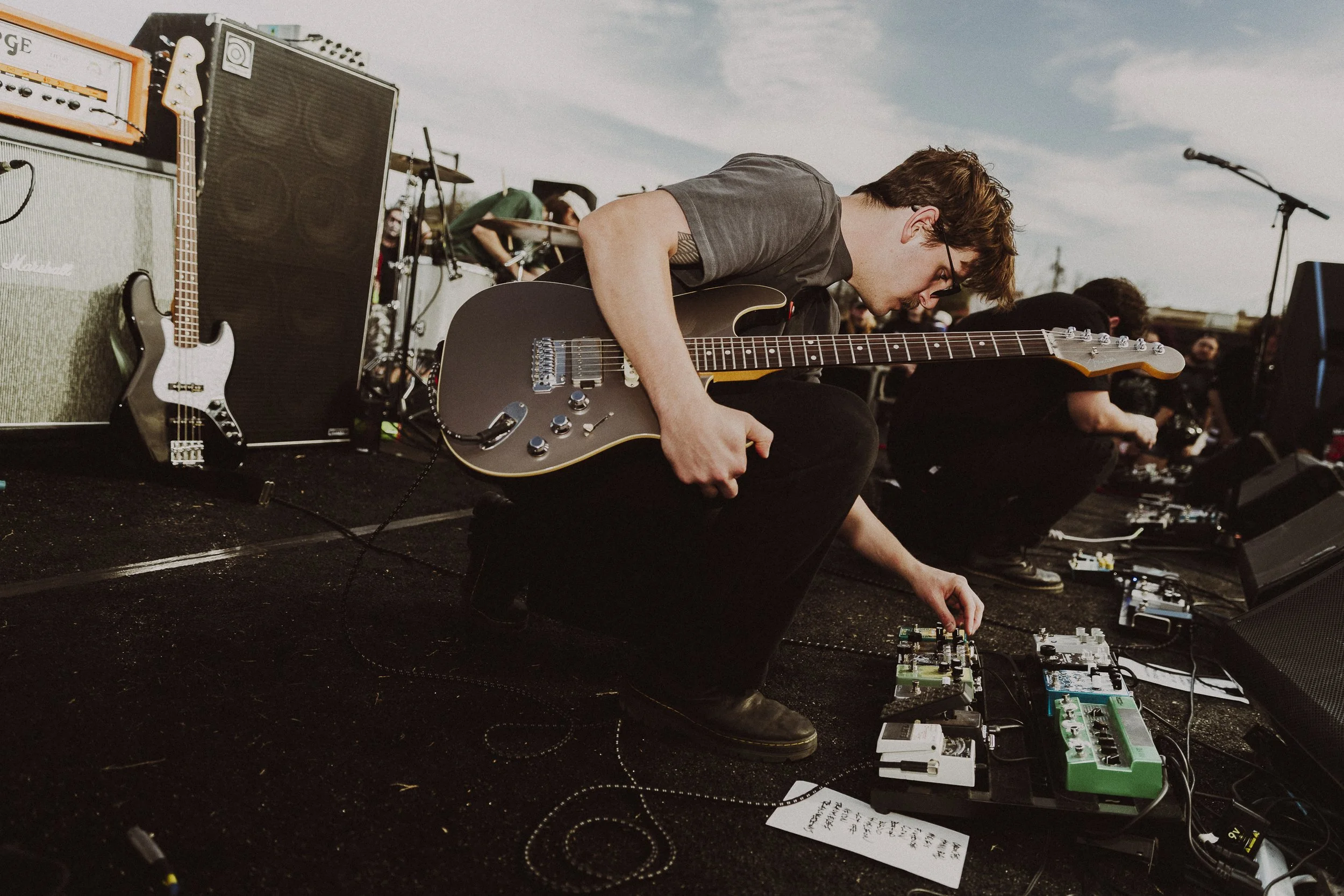 Ready for Liftoff: Trauma Ray’s Coleman Pruitt checks his pedalboard before their EP release show set in Fort Worth on March 14. Pruitt joined the band in 2019 as a last-minute addition when the other members decided a third guitar would improve thei