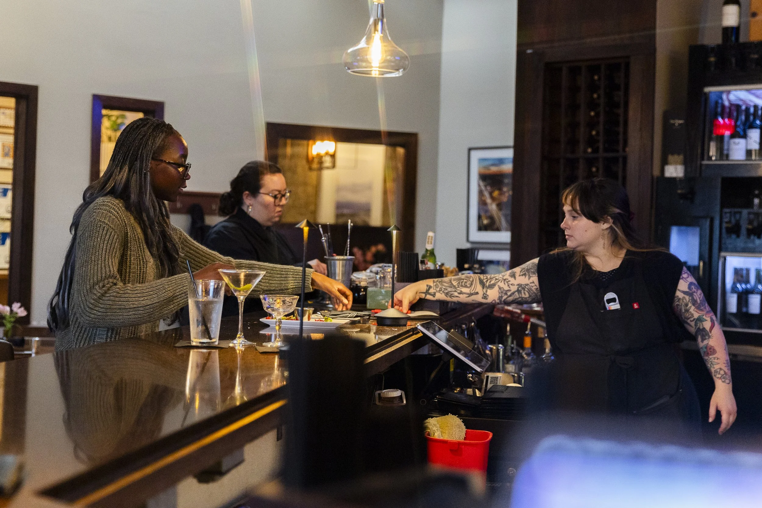 THE BAR IS HIGH: Junior Lola Popoola helps her co-workers bus the bar at Hannah’s in Denton on April 29. In addition to serving as a hostess and greeting guests, Popoola also busses tables to prepare for new customers.