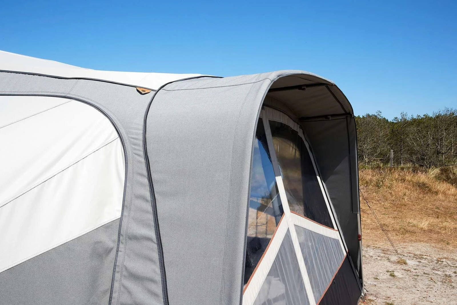 A Camp-let tent set up outdoors on a sunny day, with a grassy area and trees in the background.