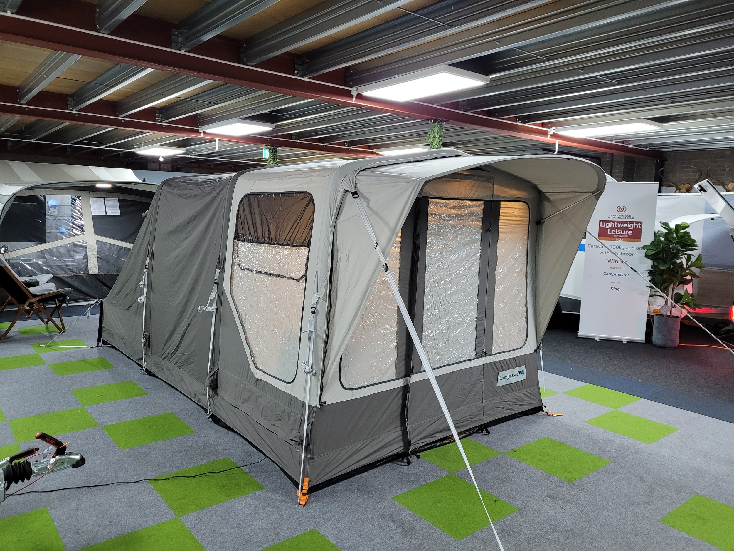 A Campamster Air on display indoors, with a sign in the background mentioning lightweight leisure camping gear.