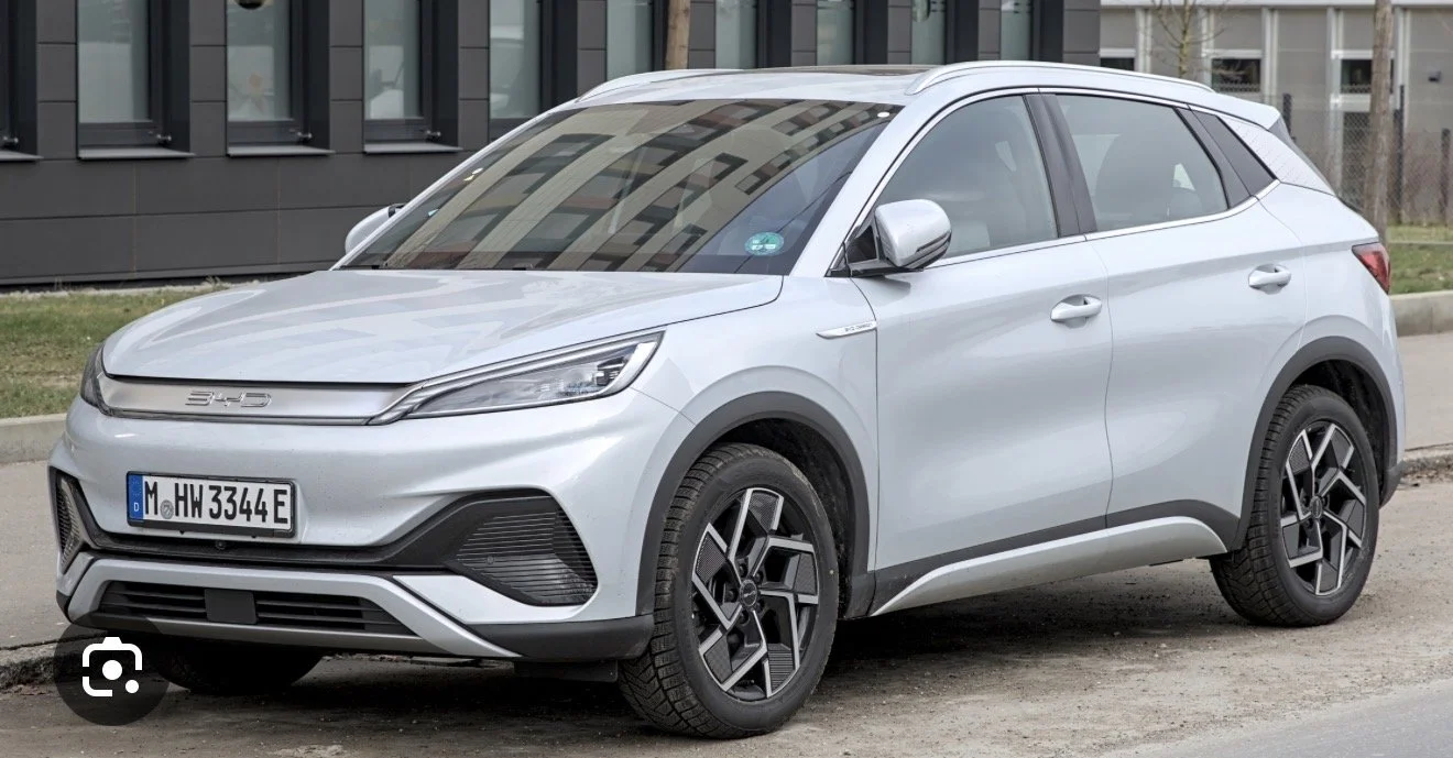 Silver SUV parked on the street in front of a modern building.