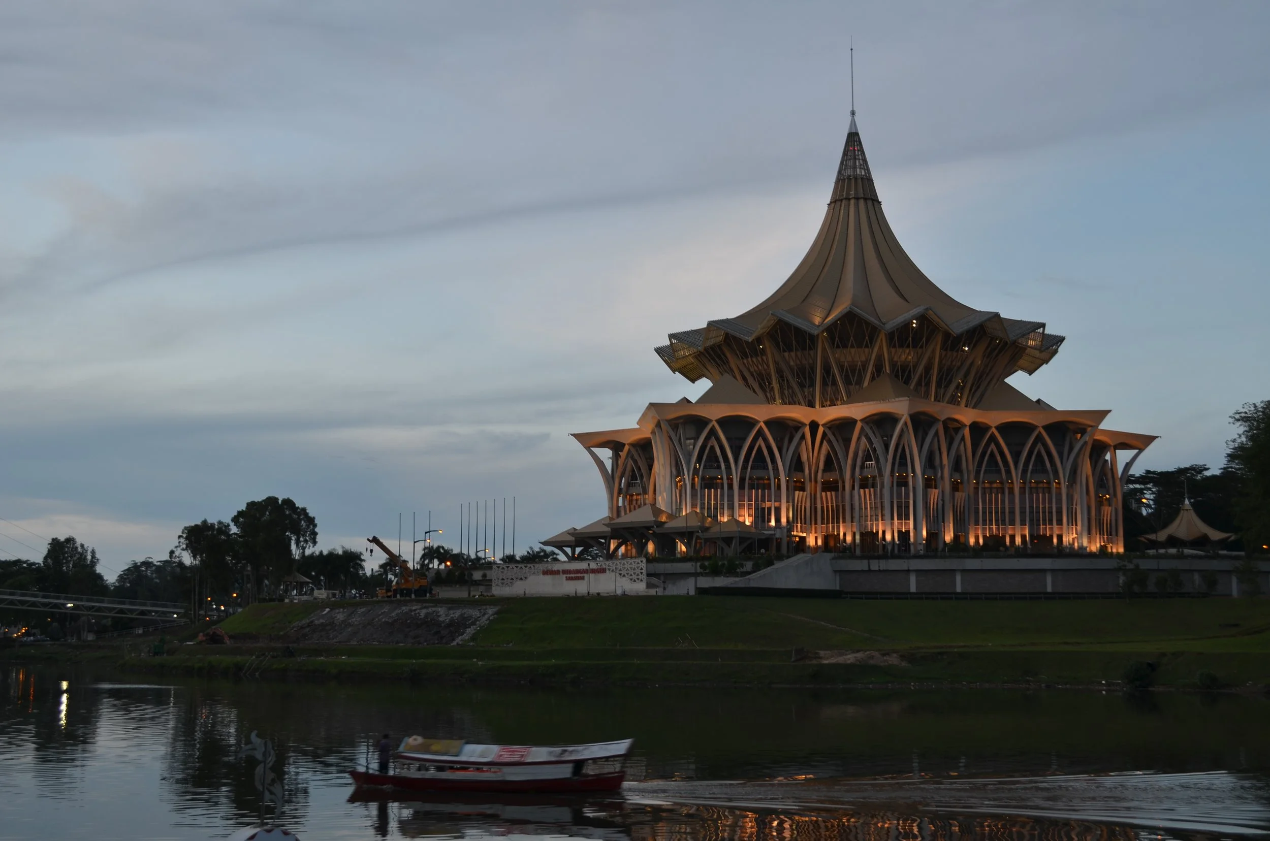 The photograph above highlights the Sarawak State Legislative Assembly Building that is lit up next to the Sarawak River during the nightfall. The structure’s unique design and its illuminations can be seen against the cloudy and soft skies during th