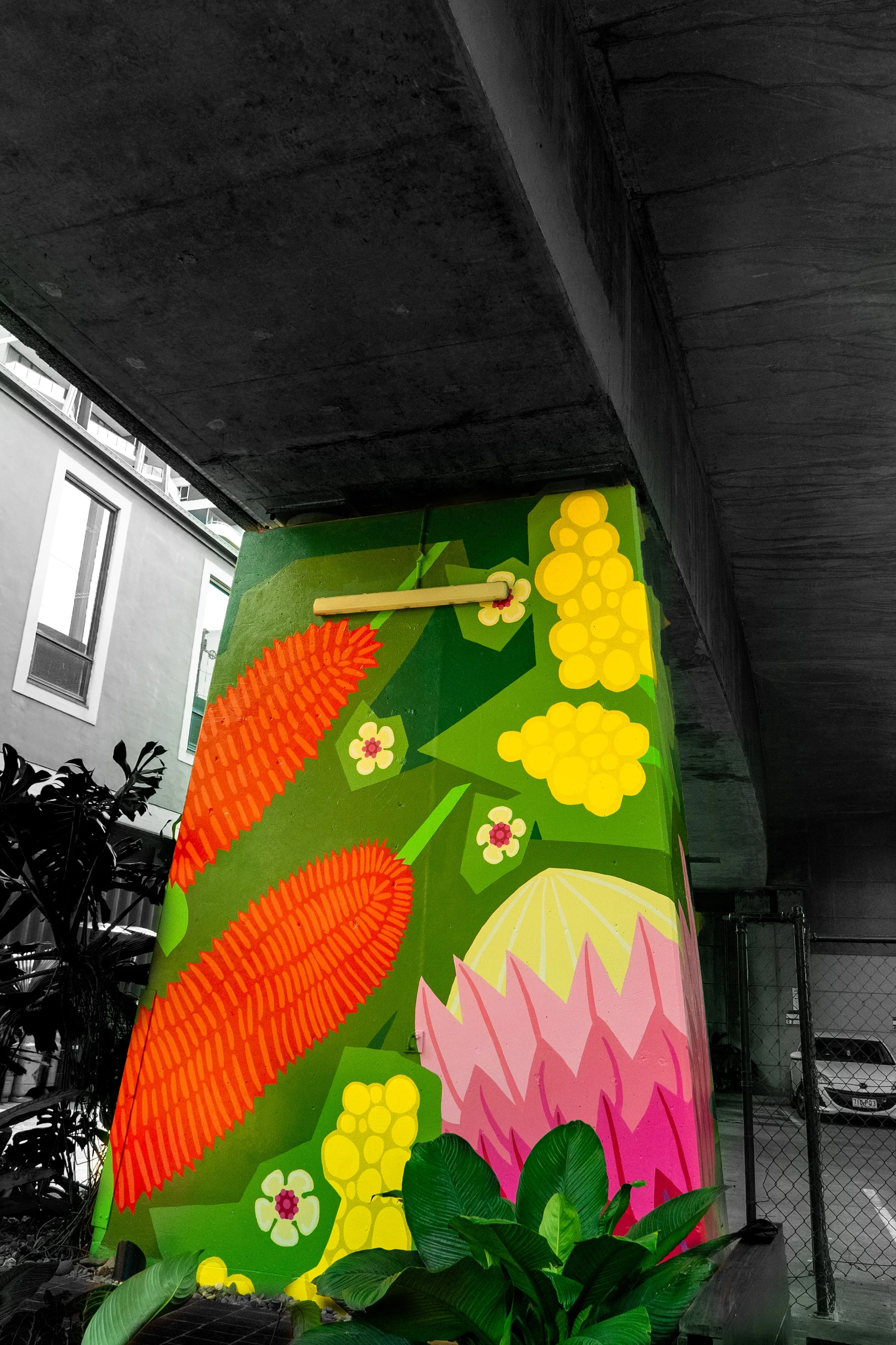 This photograph highlights a colourful mural featuring bold shapes and vibrant patterns. The contrast between the artwork and its darker surroundings creates a striking composition, celebrating creativity within public spaces.