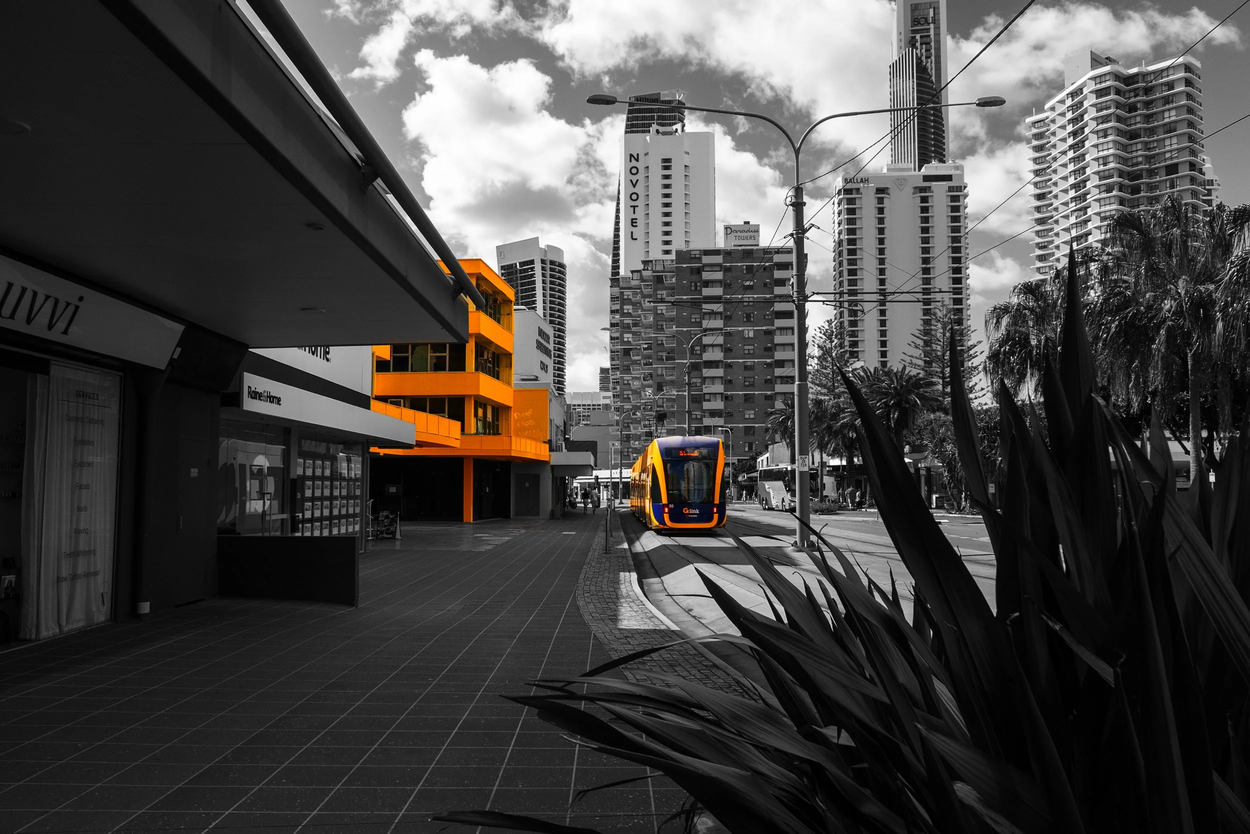 This photograph explores the relationship between modern architecture and selective colour. Bright yellow architectural features stand out against the darker urban surroundings, creating depth and guiding the viewer's attention through the compositio