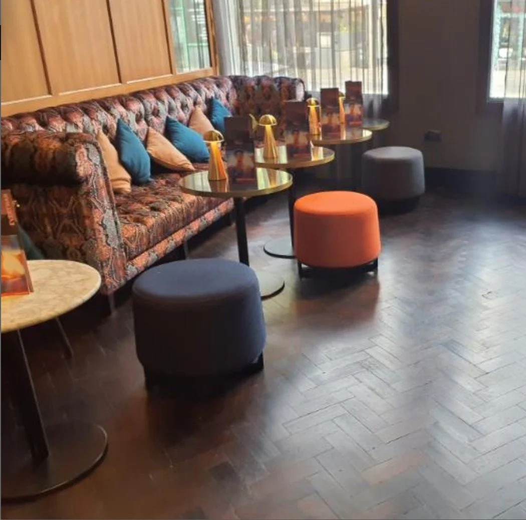 Everyman Cinema Bristol - showing the new lights installed by Medlec, a sofa, wooden flooring and orange and blue cusions with tables and the new lights