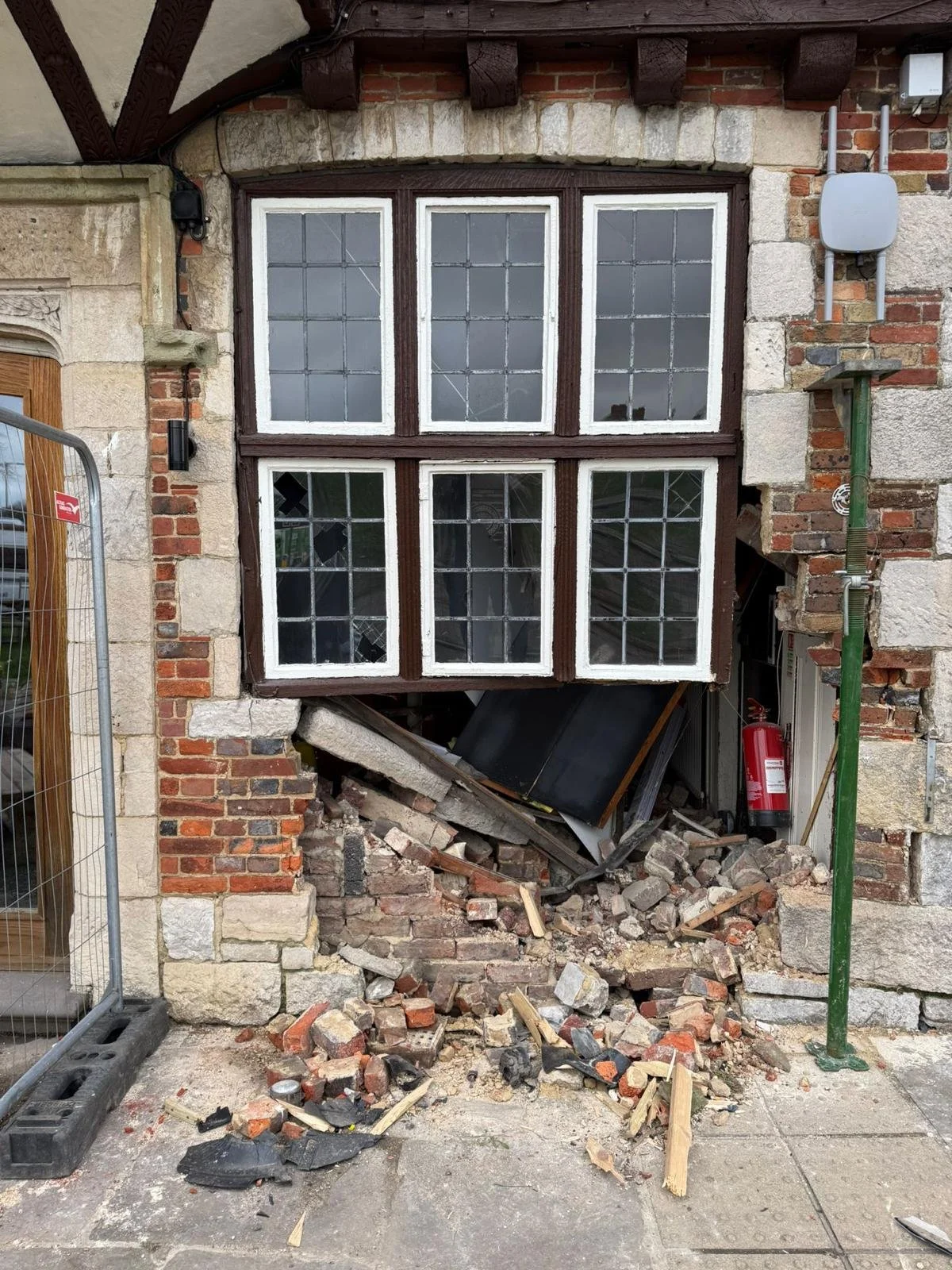 Collapsed brickwork and stonework below a pub window in Polegate