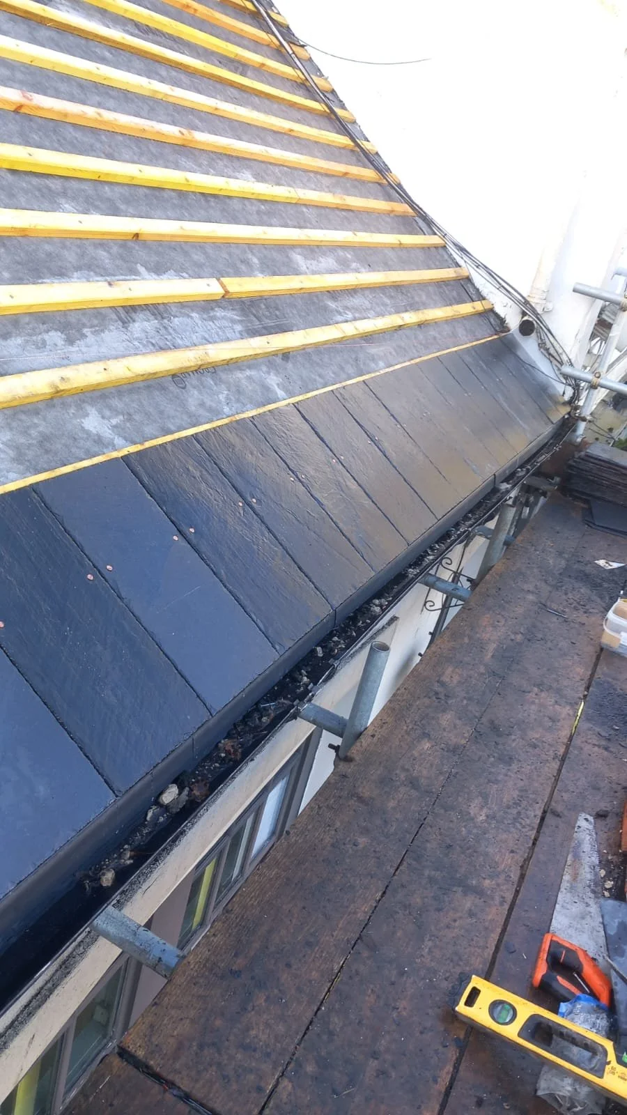 New roof being installed on a Surrey roof showing slade tiles and dry ridge system being installed