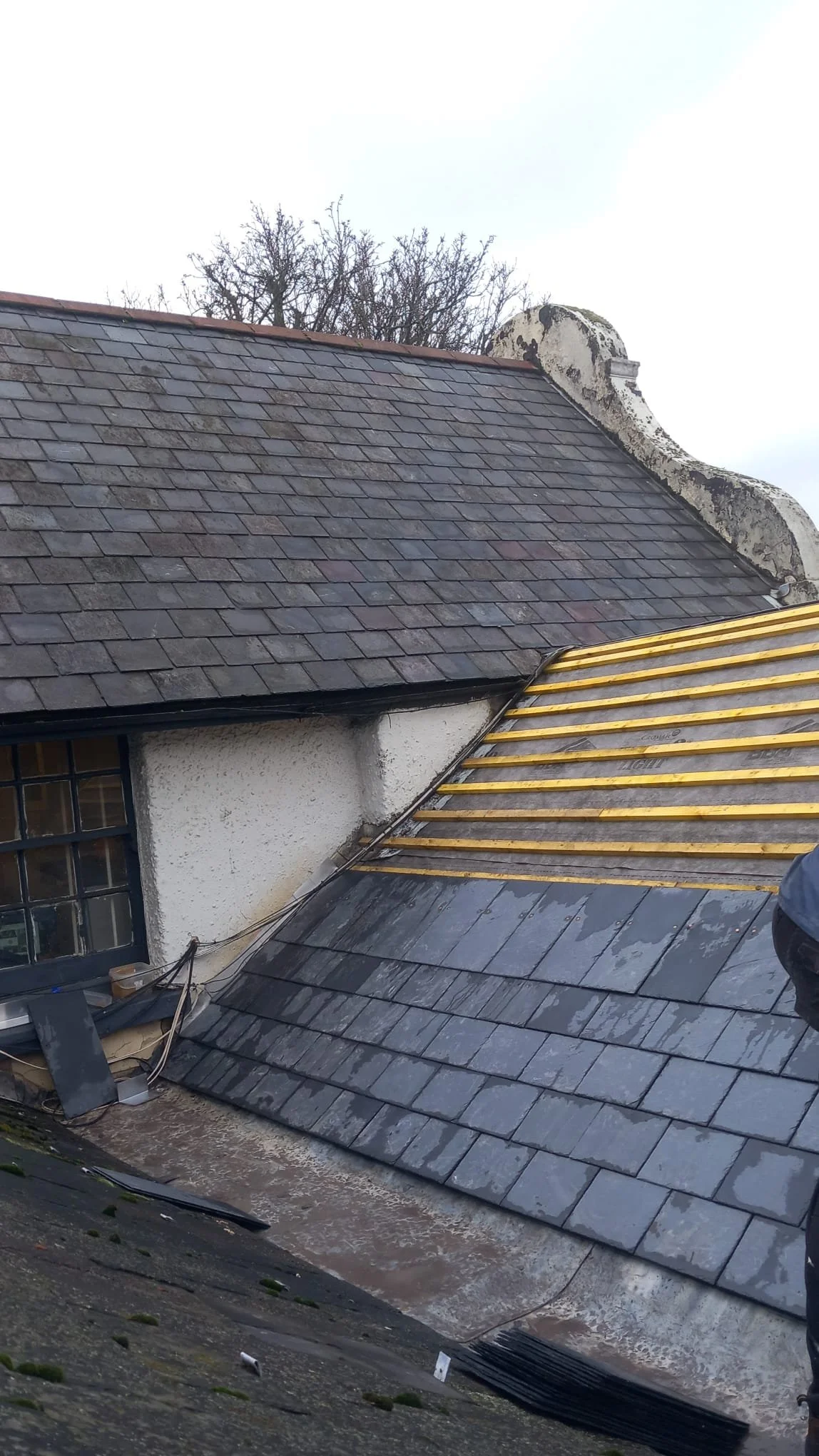 New roof being installed on a Surrey roof showing slade tiles and dry ridge system being installed